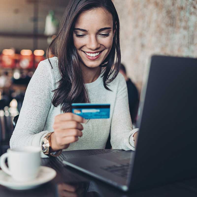 A woman using a laptop to make a payment using her credit card